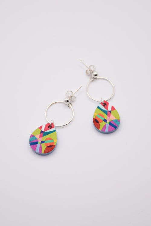 Colorful hand-painted teardrop earrings with silver hoops on a light gray background