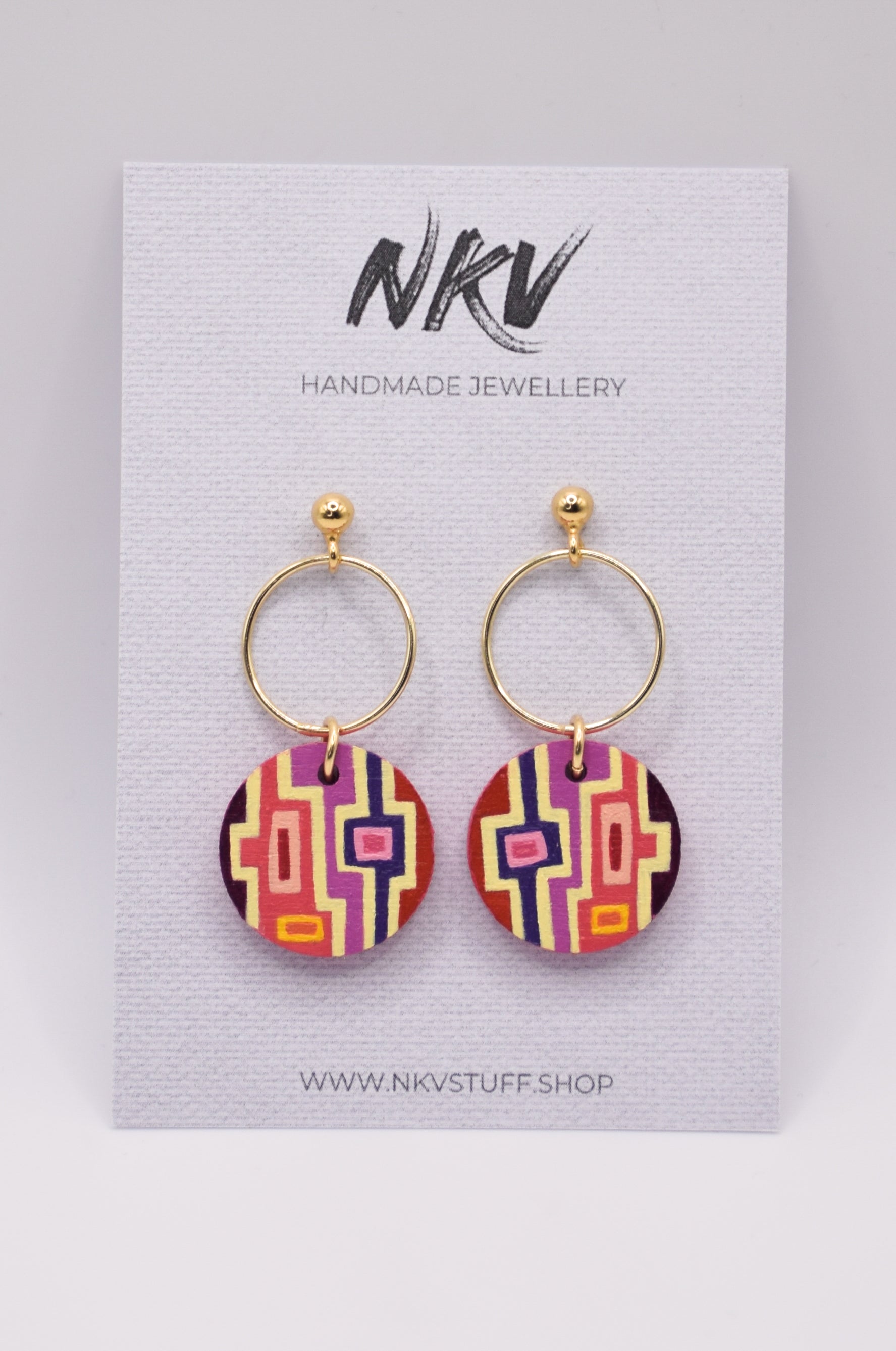 Pair of geometric patterned earrings with gold hoops on a card with 'NKV Handmade Jewellery' branding.